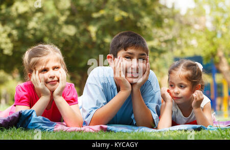 Gruppe von drei glückliche Kinder, die auf dem Gras Stockfoto