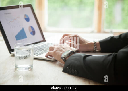 Männliche Hände über Pc Laptop, Geschäftsmann im Anzug Arbeiten mit Diagrammen Diagramme auf Bildschirm, Investor Analyse der Daten die Eingabe über Tastatur, Apps und so Stockfoto