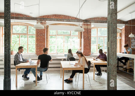 Multirassischen Menschen arbeiten in der modernen Co-working Zentrum Innere, diverse Mitarbeiter zusammen sitzen am Schreibtisch von Loft Shared Office, afrikanische kaukasischen Stockfoto