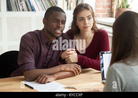 Multiethnischen paar Berücksichtigung von Erwerb von Immobilien Consulting Realtor, interracial Familie aufmerksam zuhören Broker denkst zu Hypothek Stockfoto
