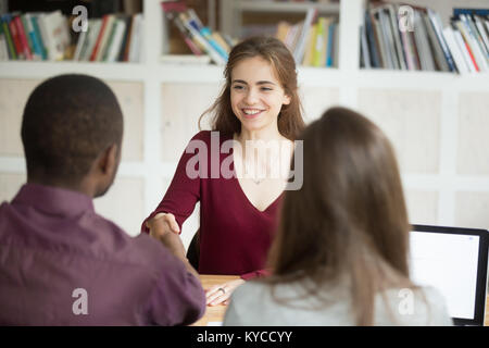 Lächelnd zuversichtlich Bewerberin zitternden Hand der Afrikanischen hr Managers, guter erster Eindruck, Arbeitgeber gratuliert attraktive Frau cand. Stockfoto