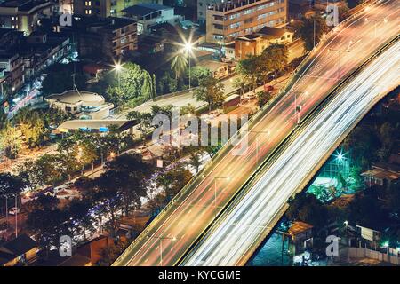 Bangkok bei Nacht. Der Verkehr auf der Hochstraße in Wohnviertel. Stockfoto