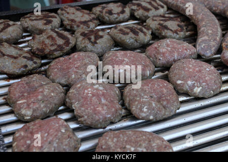 Verschiedene Art von Fleisch Steaks, Frikadellen, Shish Kebab, Filet, Burger und Würstchen mit Brot auf dem Grill. Gegrilltes Fleisch auf dem Grill Stockfoto