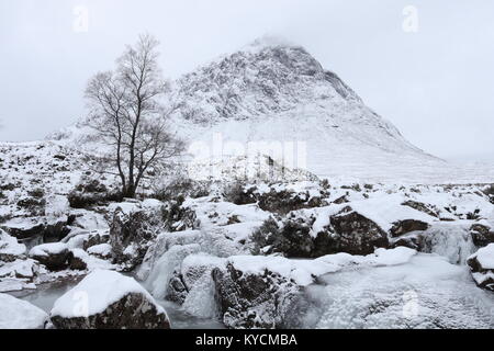 Buachaille Etive Mòr abgedeckt im Schnee hinter den gefrorenen Fluss Coupall Stockfoto