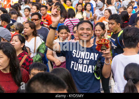 Cebu City, Philippinen. 14. Januar, 2018. Ein glückliches & lächelnde Mann hält zwei Santo Nino Figurinen. Als Teil der Sinulog 9 Tag religiöse Fest, der philippinischen Katholiken versammeln sich am frühen Morgen die Sonntagsmesse mit Santo Nino Figürchen, Repliken des Kindes Jesus. Der Glaube in diesem Bildnis stammt aus der Zeit der Entdecker Ferdinand Magellan, der die ursprüngliche Figur als Geschenk, als er im Jahr 1521 bei Cebu landeten gab. Quelle: bildergallerie 2/Alamy leben Nachrichten Stockfoto