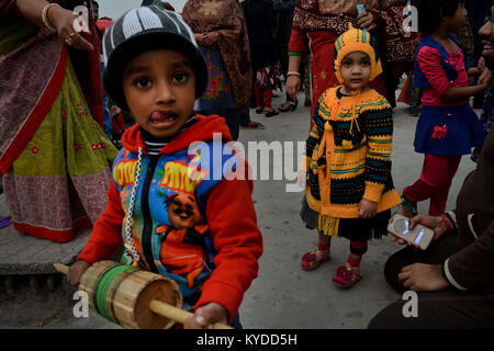 Dhaka, Bangladesch. 14 Jan, 2018. Kinder schauen in die Kamera, wie sie kamen Shakrain Festival im südlichen Teil der Hauptstadt Dhaka (Alt), Dhaka Bangladesh. Die Idee, die hinter dem Festival ist über neue Kulturen und Segen von der hinduistischen Göttin Laxmi, die Göttin der Fülle zu feiern. Dieses Festival auch als Ehegatte Songkranti bekannt. Credit: Rahman Liemu/SOPA/ZUMA Draht/Alamy leben Nachrichten Stockfoto