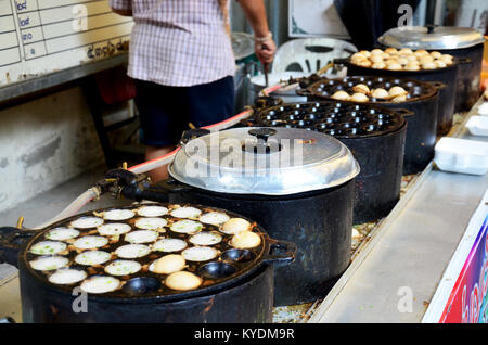 Thai Kochen Thai snack Khanom Khrok ist Kokosmilch Mix mit Pulver gebraten auf Pfannkuchen Bratpfanne zum Verkauf Leute an Market in Bangkok, Thailand Stockfoto