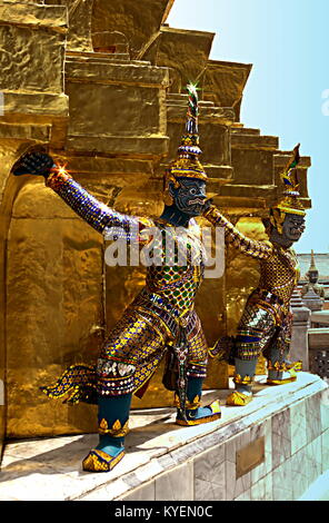 Bunte Daemon Statuen, die die Basis eines goldenen Chedi im Wat Phra Kaew, Bangkok, Thailand. Es scheint so, als ob Sie halten das chedi. Stockfoto