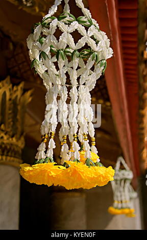 In der Nähe von typischen gelben Blumen Girlande Blume (Ringelblume), hängen vom Dach einer Pagode in einem buddhistischen Tempel, Bangkok, Thailand. Stockfoto