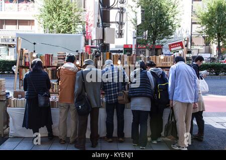 Zahlreiche ausgereifte Shopper sind hinter der Suche nach gebrauchten Büchern auf einem Markt in Jimbocho Buch Stadt, Chiyoda Bezirk, Tokyo, Japan, November 3, 2017 Stall gesehen. () Stockfoto