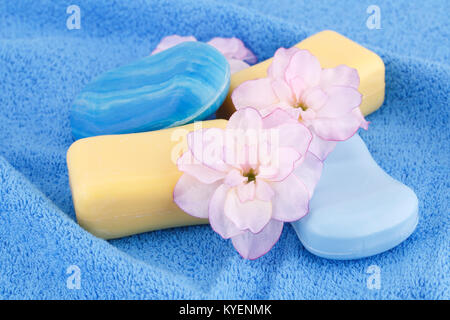 Bunte Seifen und Blumen auf blau Handtuch. Stockfoto