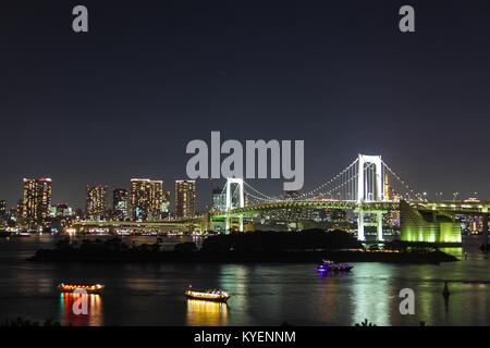 Nacht Blick auf städtischen Skyline, einschließlich der Regenbogenbrücke und Odaiba, ein Einkaufszentrum auf einer künstlichen Insel in der Bucht von Tokio, Tokio, Japan, mit yakatabune Boote sichtbar, 26. Oktober 2017. () Stockfoto