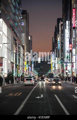 Blick auf einer belebten Straße in der Nacht mit Plakaten und Autos in der yurakucho Ginza Viertel, das für seine älteren Restaurants und Bars bekannt, im Bezirk Chiyoda der Tokio, Japan, November, 2017. () Stockfoto