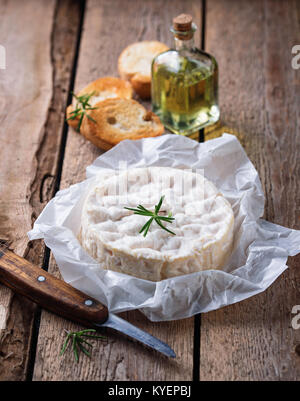 Camembert mit Rosmarin auf Holz- Hintergrund Stockfoto