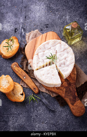 Camembert mit Rosmarin auf Holzbrett Stockfoto