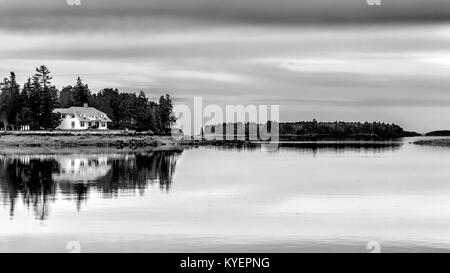 Kleine Insel mit Haus und Reflexionen in gläsernen Wassers. Ort: Maine USA. Penobscot Bay. Schwarze und weiße Schwarzweißbild. Platz kopieren Stockfoto