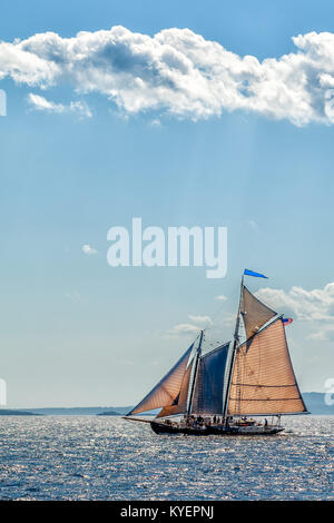 Vintage Schoneryacht aus Segeln an der Küste von Maine unter hohen Wolken und blauer Himmel. Kopieren Sie Platz. Vertikale. Stockfoto