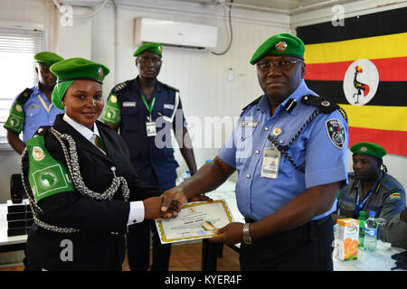 Die AMISOM Polizei Stabschef, Rex Dundun, vergibt ein Zertifikat zu einem Polizisten während einer Siegerehrung die Abfahrt von einem Kontingent von Polizisten aus Uganda in der AMISOM Hauptsitz in Mogadischu, Somalia, am 29. August 2017. Die AMISOM Foto/Ilyas Ahmed Stockfoto