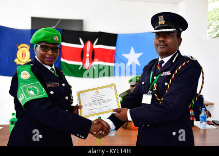 Assistant Inspector General der kenianischen Polizei (AIGP), Edward Mwamburi Hände über ein Zertifikat für eine Kenianische Polizisten, ihre Tour der Aufgabe im Rahmen der Mission der Afrikanischen Union in Somalia (AMISOM) abgeschlossen. Dies wurde bei einer Abschiedszeremonie in Mogadischu am 29. Dezember 2017. Die AMISOM Foto/Ilyas Ahmed Stockfoto