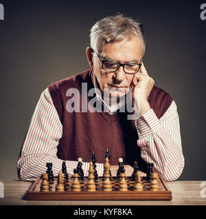 Porträt der ältere Mann, der in Schach Spiel beteiligt ist. Stockfoto