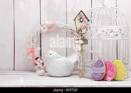 Frohe Ostern Dekoration für Grußkarten. Holz- Vogel, Vogelhaus, Lebkuchen Ostern Cookies in Form von Ostereiern auf weißem Hintergrund. Vintage sty Stockfoto