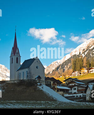 Frühjahr schmilzt der Schnee auf dem Hügel mit dem kleinen Berg Kirche Stockfoto