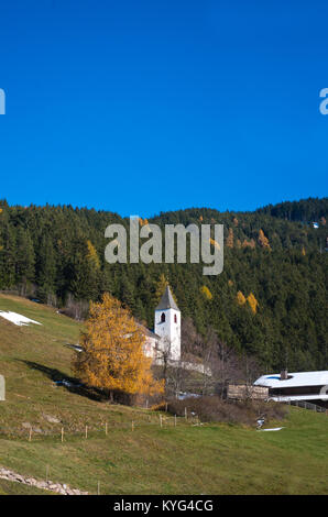 Frühjahr schmilzt der Schnee auf dem Berg mit der kleinen Kirche in der Nähe der Großen Baum Stockfoto