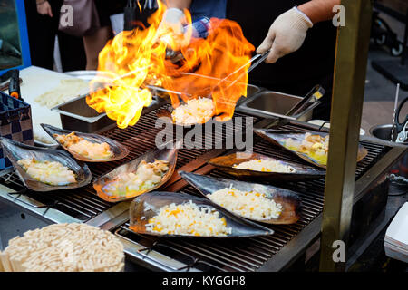 Gehackter frischer Atrina Larix spp., mit Käse auf die Oberseite, gekocht von einem Flammenwerfer (Koreanische Street Food) Stockfoto