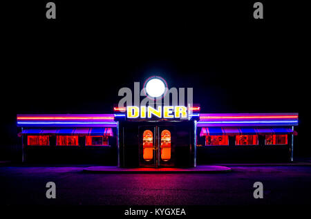 Ein traditionell amerikanisches Diner in der Nacht mit einem großen Schild und clorful leuchtend, Fluourescent und Neon Beleuchtung, die im Dunkeln leuchtet. Stockfoto