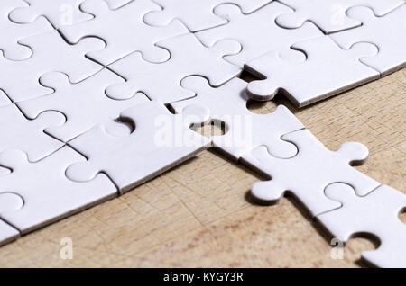 Weiß Stichsäge/Puzzle mit einer Zeile in falscher Position, über holztisch Hintergrund, Symbol der Problemlösung und neue Vision Stockfoto