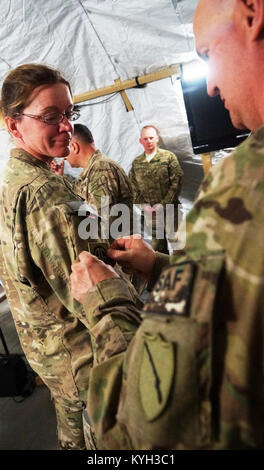 Kentucky Agribusiness Development Team 4 Sgt. 1. Klasse Michele Owen (links), ein Bewohner von Bowling Green, Ky. Ihre Bekämpfung Patch erhält von ADT 4 Kommandant Oberst Tommy Barriere (rechts), ein Bewohner von Versailles, Ky. während einer Zeremonie am 14. März 2012. Die Zeremonie wird in der Regel bedeutete zum Gedenken an eine Armee Einheit mehr als 30 Tage im Land, indem Sie die Vergabe der Patch ihrer Kommandierenden Einheit auf der rechten Schulter getragen werden. In der ADT4 Fall, ihre dominierende Einheit war, Fort Bragg, N.C. der renommierten 82nd Airborne Division. (Foto von der U.S. Army Staff Sgt. Paul Evans) Stockfoto