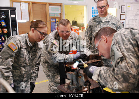 Spc. Johnna Freyer und Mitglieder der 307th Komponente reparieren Unternehmen beobachten, wie Spc. James Cabell demonstriert Lötverfahren während ihrer jährlichen Fortbildung auf nationaler Wartung Training Center (NMTC) in Camp Dodge, Iowa, Mai 2012. (Kentucky National Guard Foto von Sgt. Dale Elliott) Stockfoto