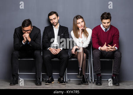 Die Menschen werden immer beim Sitzen auf Stuhl warten auf Job Interview langweilig Stockfoto
