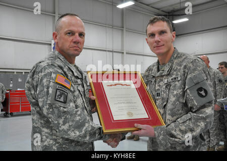 Brig. Gen. Stephen Hogan, stellvertretender Adjutant General für Ausbildung, stellt die übergeordnete Einheit Preis an Kapitän Stephen Martin, Kommandeur der Bravo Co., 2.BATAILLON, 147 aviation Regiment an der Boone National Guard Center, Hanger 2 in Frankfort, Ky. Dez. 1, 2012. (Foto von SPC. Tom Harrington, Unit Public Affairs Historiker Vertreter) Stockfoto