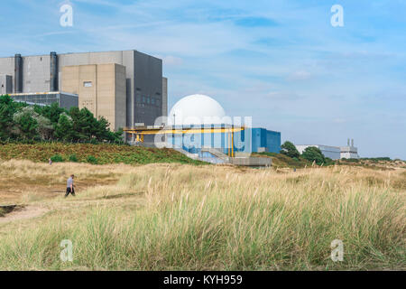 Sizewell Suffolk UK, Blick auf einen Mann, der durch Sanddünen in der Nähe des Kernkraftwerks Sizewell B an der Suffolk Küste, England, UK, läuft. Stockfoto