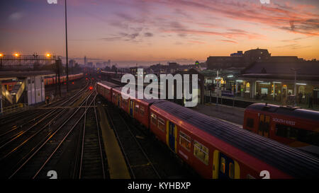 Züge in Clapham Junction, einem der verkehrsreichsten Bahnhöfe der Welt, überschrift in London für den Morgen pendeln. Stockfoto