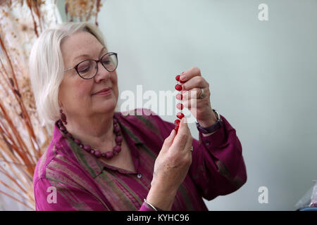 Eine Frau, die ein Halsband mit einer Halskette, Kit in Ihrem Haus in Sussex, UK. Stockfoto