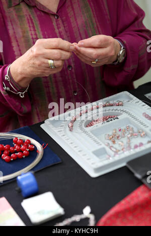 Eine Frau, die ein Halsband mit einer Halskette, Kit in Ihrem Haus in Sussex, UK. Stockfoto