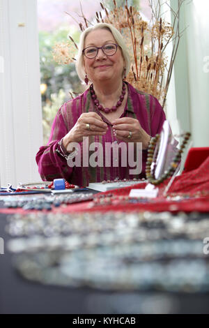 Eine Frau, die ein Halsband mit einer Halskette, Kit in Ihrem Haus in Sussex, UK. Stockfoto