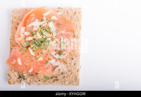 Geräucherter Lachs auf Toast mit Zwiebel und Petersilie isoliert auf weißem Hintergrund Stockfoto