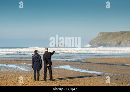 Polzeath - ein reifes Paar Leute stehen auf Polzeath Strand genießen den Blick Küste von North Cornwall. Stockfoto