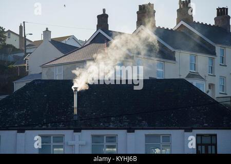 Polzeath - aufsteigenden Rauch aus einem Schornstein aus Metall auf einem Haus in Polzeath Stadt in Cornwall. Stockfoto