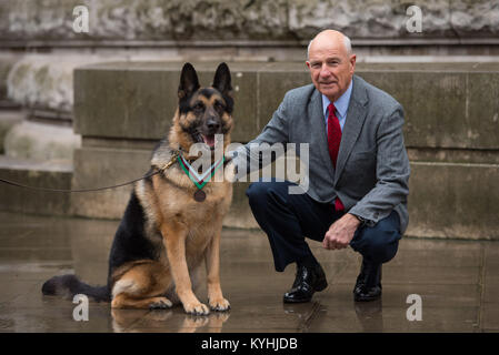 US-Militär Gebrauchshund Ayron, der posthum eine PDSA Dickin Medal im Namen von Chips, ein WWII US Army Hund erhalten hat, mit Chips "ehemalige Inhaber John Wren. Chips wird zum Schutz des Lebens von seinem platoon während der Invasion und der Strand, die Anlandungen von Sizilien im Jahr 1943 erkannt. Stockfoto