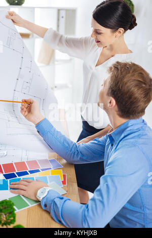 Junge Ingenieur ihre Zeichnung, mit einem erfahrenen Kollegen Stockfoto