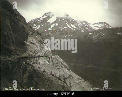 Diese historische Szene aus der Zeit um 1898 zeigt den White Pass und die Yukon Route in der Nähe von Tunnel Mountain, Alaska. Das Bild erfasst das bergige Gelände und das Eisenbahnsystem, das während des Goldrausches von Klondike eine entscheidende Rolle in der Transportgeschichte der Region spielte. Stockfoto