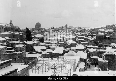 Foto mit schneebedeckten Dächern in Jerusalem im Jahr 1921, mit einer Moschee in der Ferne, die städtische Landschaft und architektonische Besonderheiten darstellt. Stockfoto