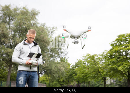 Mann Betrieb der Quadrocopter im Park Stockfoto
