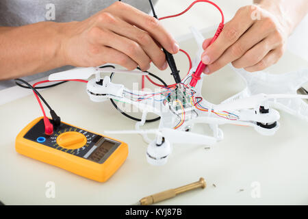 Nahaufnahme eines Mannes Prüfung elektrischer Strom von zerlegt Drone mit Multimeter Werkzeug Stockfoto
