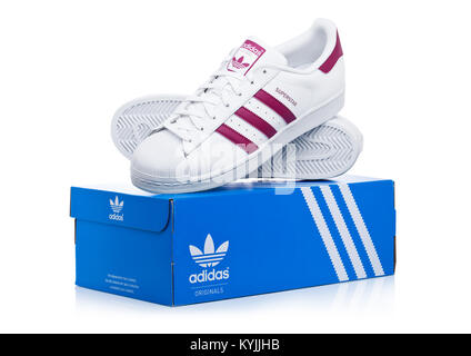 LONDON, Großbritannien - 12 Januar, 2018: Adidas Superstar rote Schuhe mit Box auf weißem Hintergrund. Deutsche multinationale Unternehmen, Designs und Mann Stockfoto