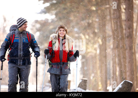 Männliche und weibliche junge Wanderer wandern in verschneite Natur Stockfoto